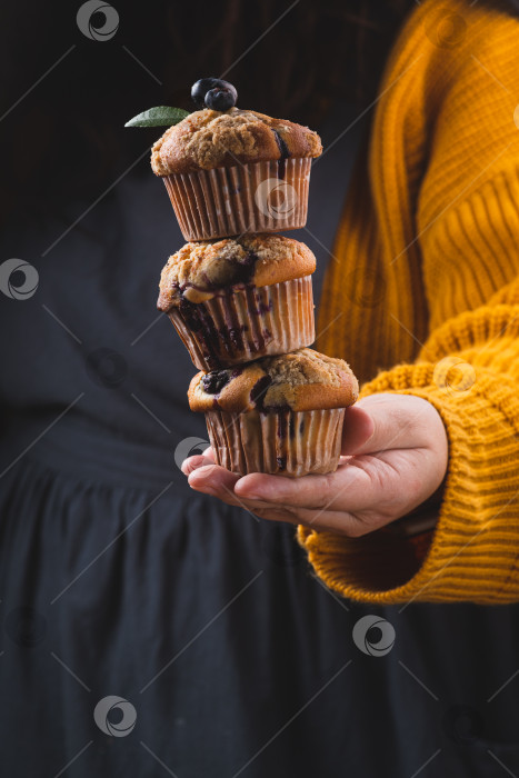 Скачать Стопка черничных маффинов в руках женщины фотосток Ozero