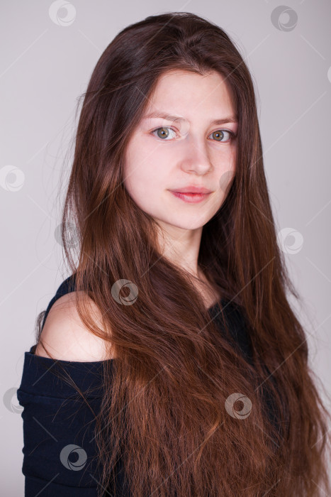 Скачать Крупный план портрета молодой красивой девушки, выделенной на сером фоне фотосток Ozero