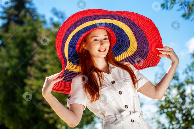 Скачать Портрет молодой красивой девушки в соломенной шляпке, позирующей в летнем парке фотосток Ozero