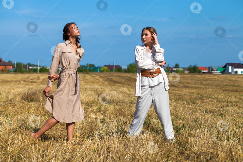 Скачать Две красивые модели в бежевых костюмах позируют на фоне пшеницы в скошенном поле фотосток Ozero