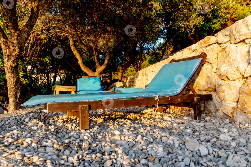 Скачать Оборудованный галечный пляж Адриатического моря, пустые шезлонги на закате, Утеха, Черногория фотосток Ozero