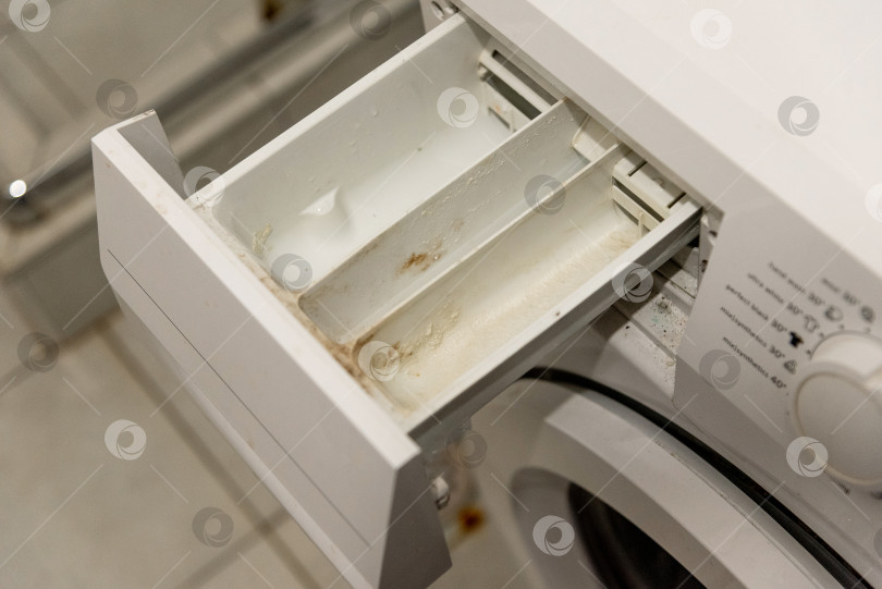 Скачать Грязный поддон в ящике стиральной машины, покрытый моющим средством, и твердый водяной налет фотосток Ozero