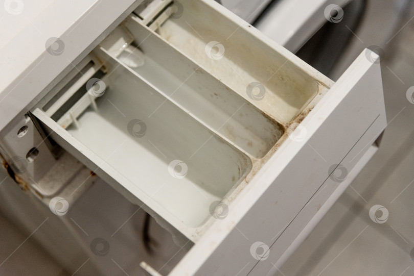 Скачать Грязный поддон в ящике стиральной машины, покрытый моющим средством, и твердый водяной налет фотосток Ozero