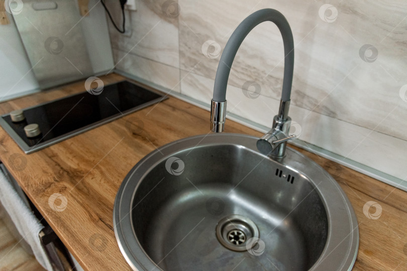 Скачать Круглая раковина и гибкий смеситель - удобные интерьерные решения для дизайна кухни фотосток Ozero