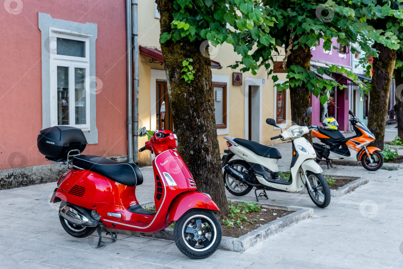 Скачать Цетинье, Черногория, 3 августа 2025 года, Скутеры и велосипеды припаркованы на тротуаре улицы фотосток Ozero