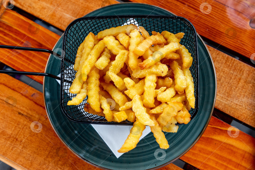 Скачать Золотистый гофрированный Картофель Фри На тарелке, Американский Фаст-Фуд В Ресторане фотосток Ozero