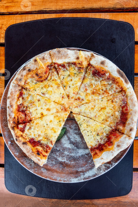 Скачать Пицца "Маргарита", нарезанная кусочками на круглой тарелке, итальянская выпечка в пиццерии фотосток Ozero