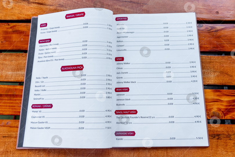 Скачать Цетинье, Черногория, 3 августа 2025 года, меню открытого ресторана разложено на деревянном столе фотосток Ozero