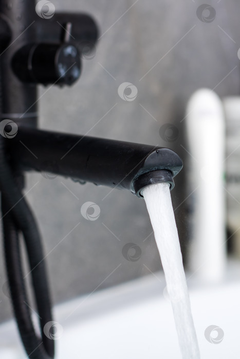 Скачать Современный черный смеситель с проточной водой в стильной ванной комнате фотосток Ozero