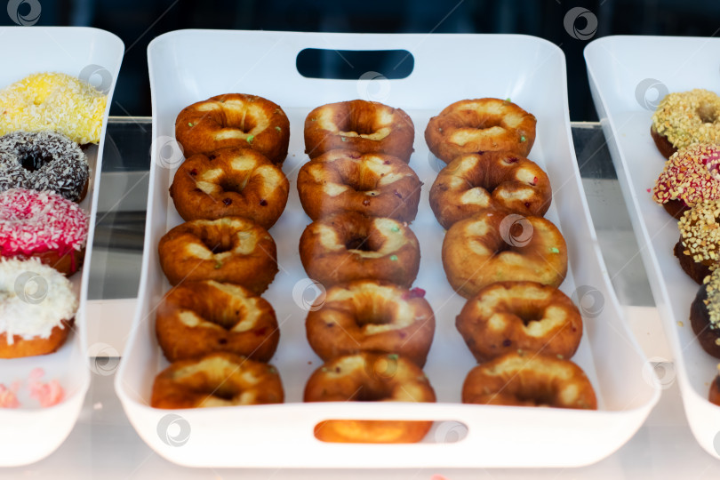 Скачать Красивая выкладка свежеиспеченных пончиков на подносе для всех фотосток Ozero