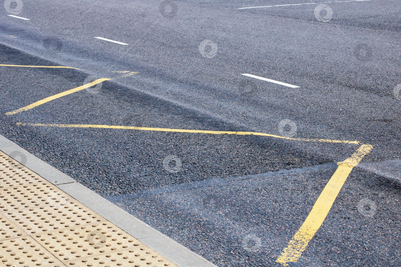 Скачать Крупный план асфальтированной улицы с желтыми линиями парковки и текстурами фотосток Ozero