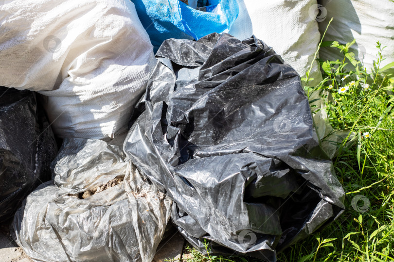 Скачать Коллекция разнообразных мешков для мусора, представленная в красивом парке фотосток Ozero