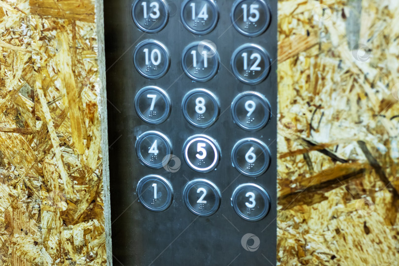Скачать Это крупный план современной панели управления лифтом, расположенной на деревянной панели фотосток Ozero