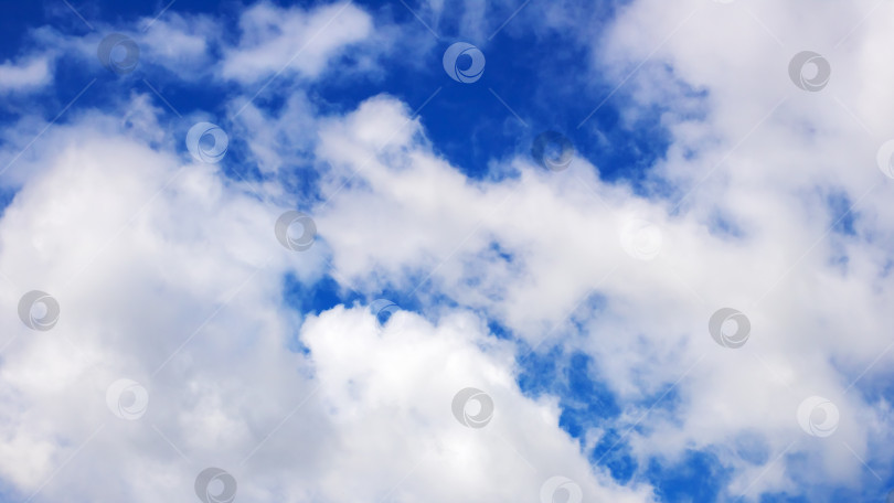 Скачать Небо потрясающего ярко-голубого цвета, украшенное пушистыми белыми облаками фотосток Ozero
