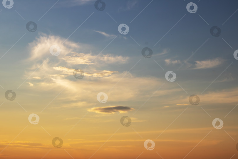 Скачать Безмятежное закатное небо, наполненное мягкими облаками и теплыми оттенками цвета фотосток Ozero