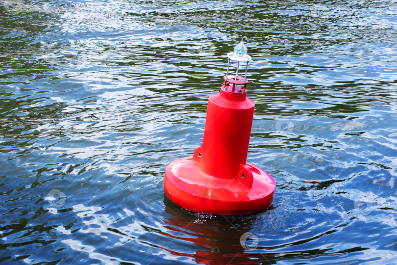 Скачать Ярко-красный буй, грациозно плывущий по поверхности воды фотосток Ozero