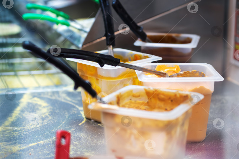 Скачать Выбор соусов в кухонных контейнерах с помощью щипцов фотосток Ozero