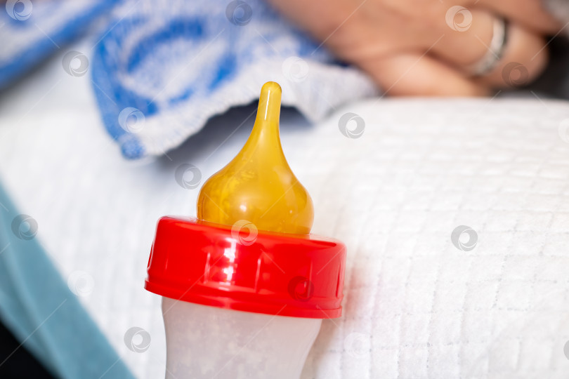 Скачать Детская бутылочка с желтой соской, поставленная на мягкую поверхность фотосток Ozero