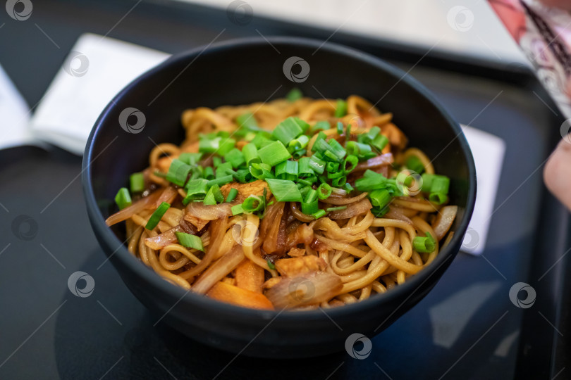 Скачать Вкусная лапша, обжаренная во фритюре, с мелко нарезанным зеленым луком фотосток Ozero