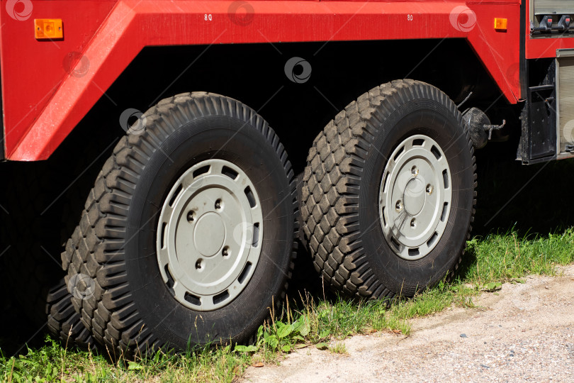 Скачать Подробный вид грузовых шин, установленных на красном транспортном средстве, крупным планом фотосток Ozero