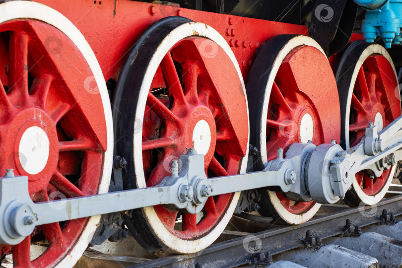 Скачать Старинные колеса парового двигателя с красными спицами и белыми вставками фотосток Ozero