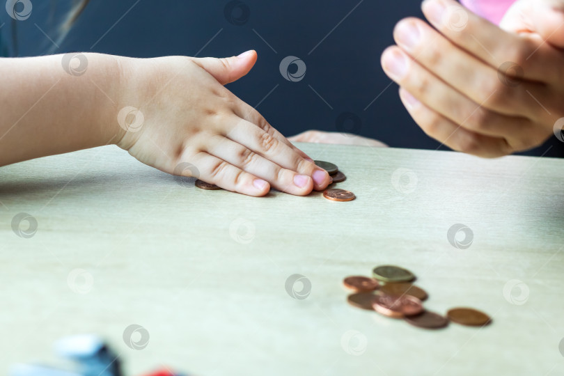 Скачать Группа детей радостно играет с блестящими монетками на столе фотосток Ozero