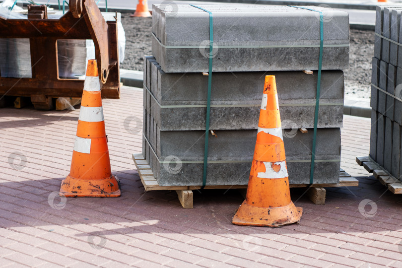Скачать Строительная площадка с дорожными конусами и уложенной друг на друга тротуарной плиткой фотосток Ozero