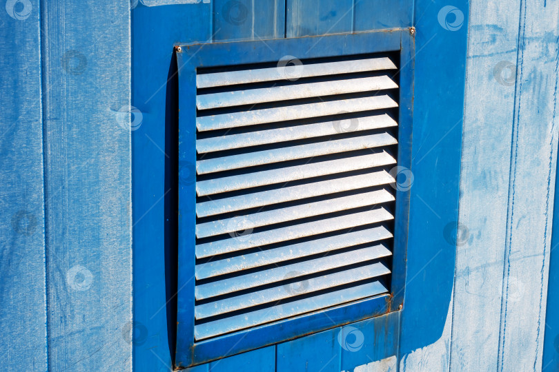 Скачать Детализированный снимок крупным планом синего вентиляционного отверстия, расположенного на деревянной конструкции фотосток Ozero