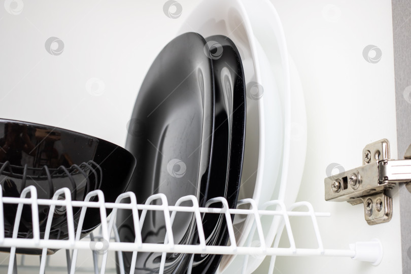 Скачать Элегантная стопка тарелок, выставленная в стильном кухонном шкафу фотосток Ozero