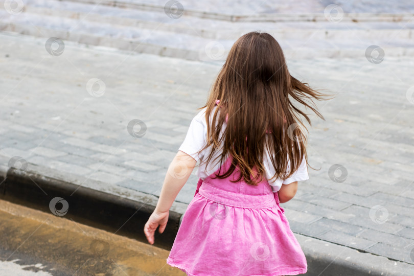 Скачать Молодая девушка в ярко-розовой юбке наслаждается играми и весельем на свежем воздухе фотосток Ozero