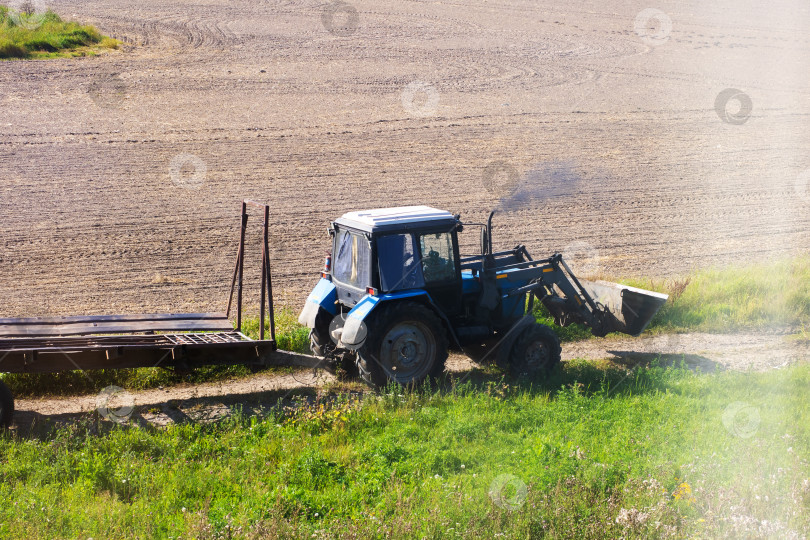 Скачать В настоящее время трактор усердно работает на сельскохозяйственном поле фотосток Ozero