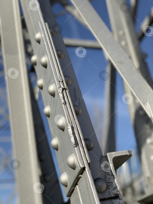 Скачать Крупный план стальной конструкции моста с заклепками в фокусе на фоне ясного голубого неба фотосток Ozero