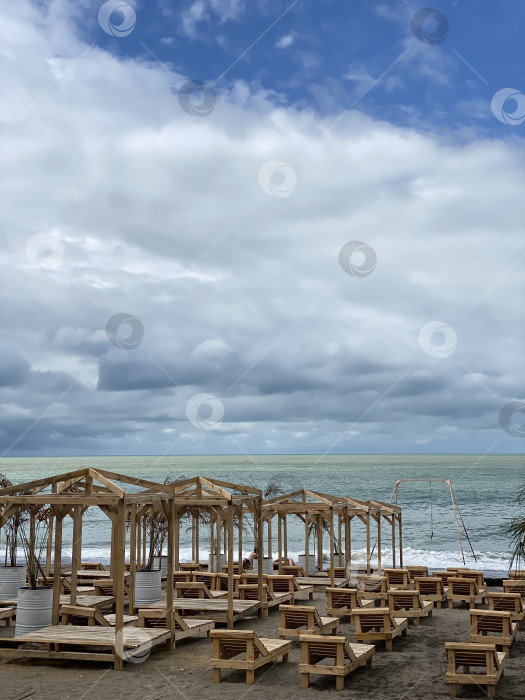Скачать Пляжные домики расположены вдоль живописной береговой линии под облачным небом и идеально подходят для рекламы путешествий и отдыха фотосток Ozero