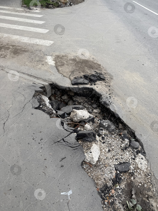 Скачать Эрозия обочин обнажает поврежденное асфальтовое покрытие и нижележащие слои почвы фотосток Ozero