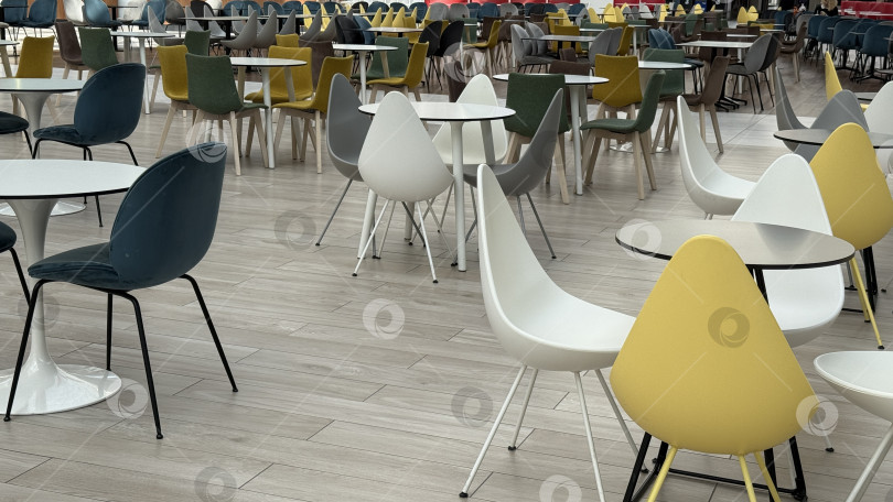 Скачать Пустой кафетерий с разноцветными стульями и столами, подходящий в качестве фона для различных тем фотосток Ozero
