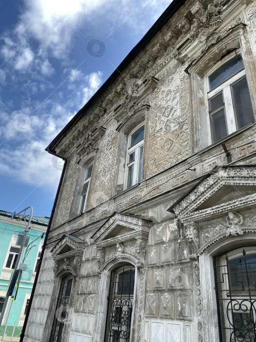Скачать Богато украшенный фасад исторического здания на фоне голубого неба с облаками, подходящий для архитектурного фона фотосток Ozero