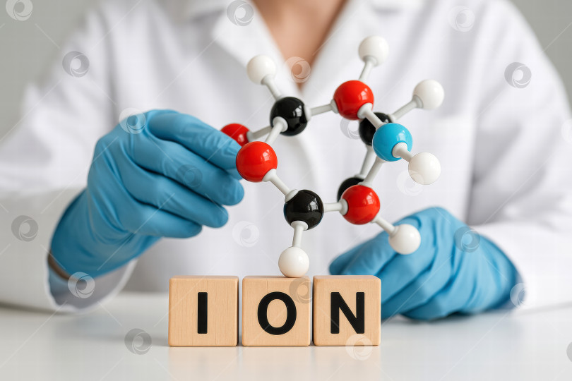 Скачать Ученый собирает молекулярную структуру, представляющую ионы, демонстрируя химию в действии с помощью красочных моделей и обучающих блоков фотосток Ozero