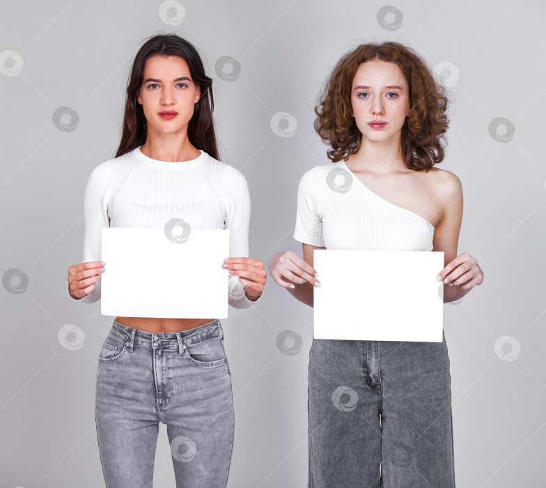 Скачать Две молодые девушки с чистым листом бумаги - место для надписи фотосток Ozero