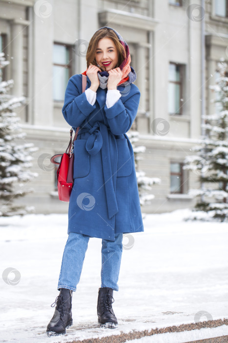 Скачать Портрет молодой девушки в синих джинсах, прогуливающейся по зимнему парку фотосток Ozero