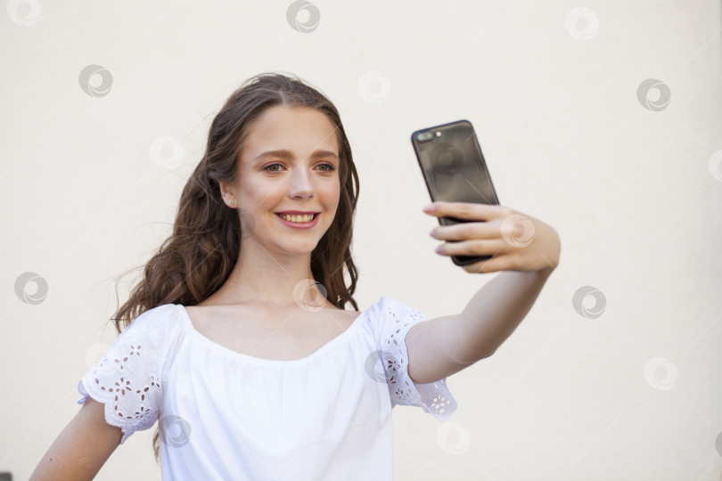 Скачать Симпатичная молодая брюнетка делает селфи на смартфоне фотосток Ozero