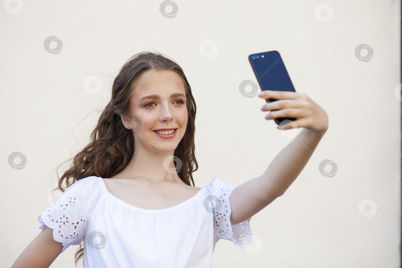 Скачать Симпатичная молодая брюнетка делает селфи на смартфоне фотосток Ozero