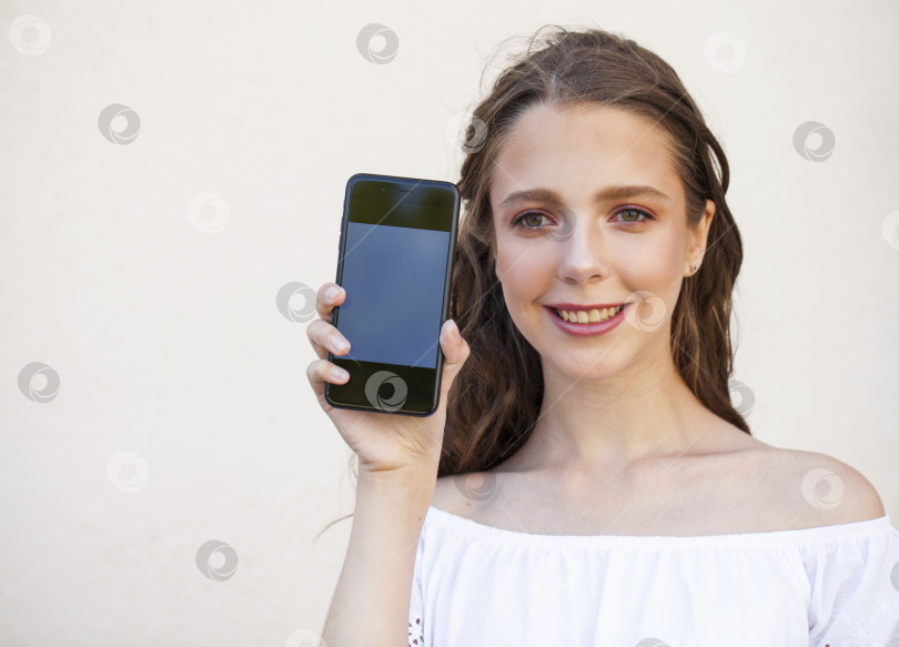 Скачать Красивая девушка показывает экран твоего смартфона фотосток Ozero