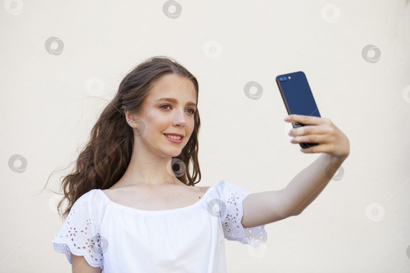 Скачать Симпатичная молодая брюнетка делает селфи на смартфоне фотосток Ozero