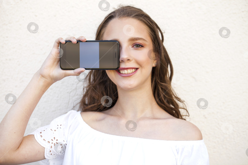 Скачать Красивая девушка показывает экран твоего смартфона фотосток Ozero