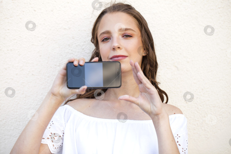 Скачать Красивая девушка показывает экран твоего смартфона фотосток Ozero