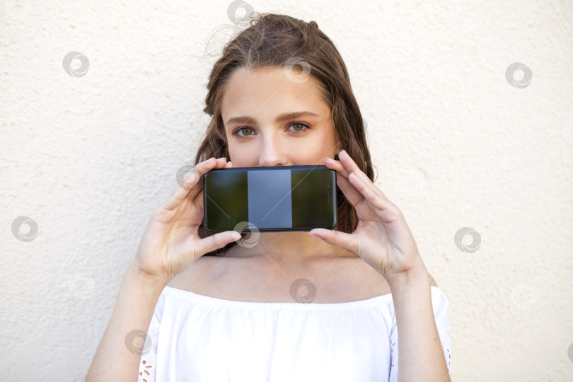 Скачать Красивая девушка показывает экран твоего смартфона фотосток Ozero
