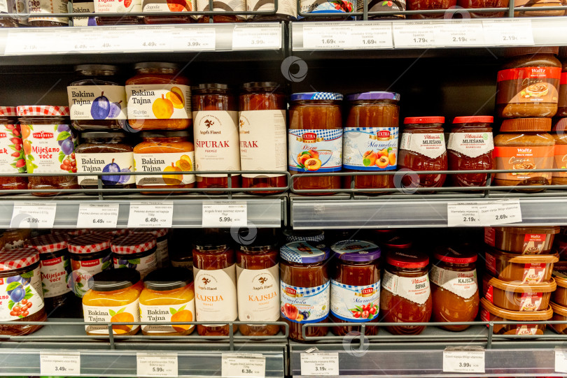 Скачать Бар, Черногория, 22 августа 2025 года, стеклянные банки с фруктовым джемом на полках супермаркета фотосток Ozero