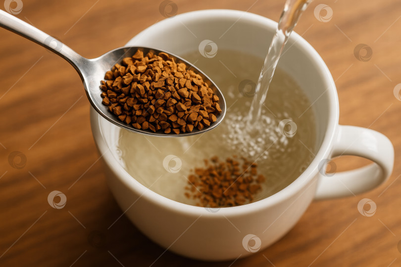 Скачать Завариваем растворимый кофе: Заливаем гранулы горячей водой в белой кружке, чтобы напиток получился насыщенным и приятным фотосток Ozero