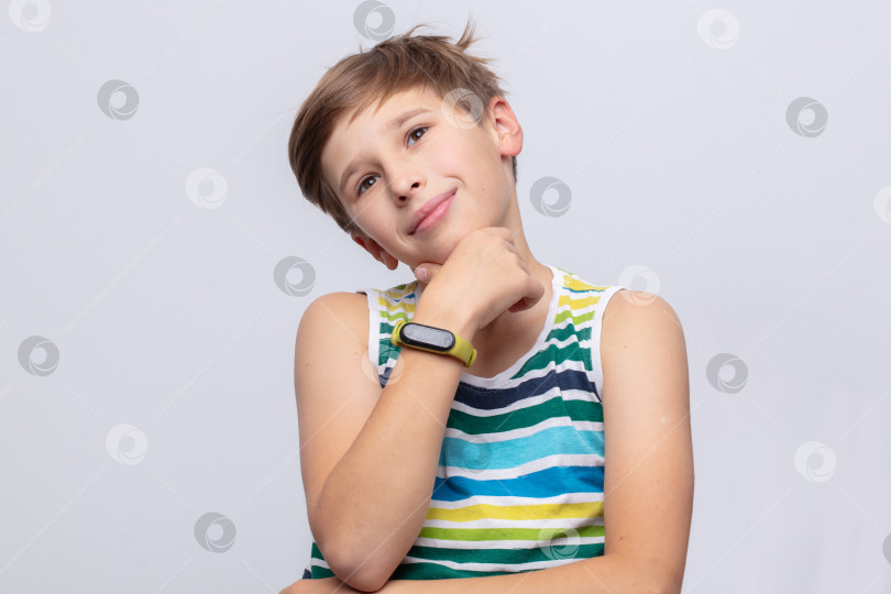 Скачать Молодой человек в полосатой рубашке задумчиво позирует, демонстрируя игривое выражение лица в простой обстановке фотосток Ozero