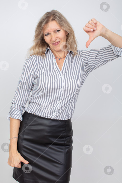 Скачать Женщина, выражающая неодобрение в полосатой рубашке и кожаной юбке на простом фоне фотосток Ozero